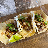 テイクアウト容器に入ったタコスの写真